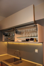 кухня по индивидуален проект, изработка от ламинирано ПДЧ, МДФ – гланц лак, термоплот, механизми за вертикално отваряне на врати в горен ред с вградено плавно затваряне
